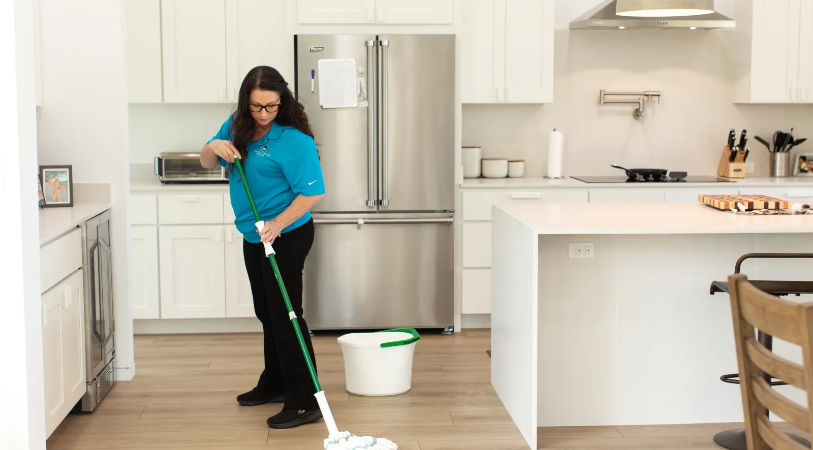 A Sandcastle caregiver mopping a client's kitchen floor