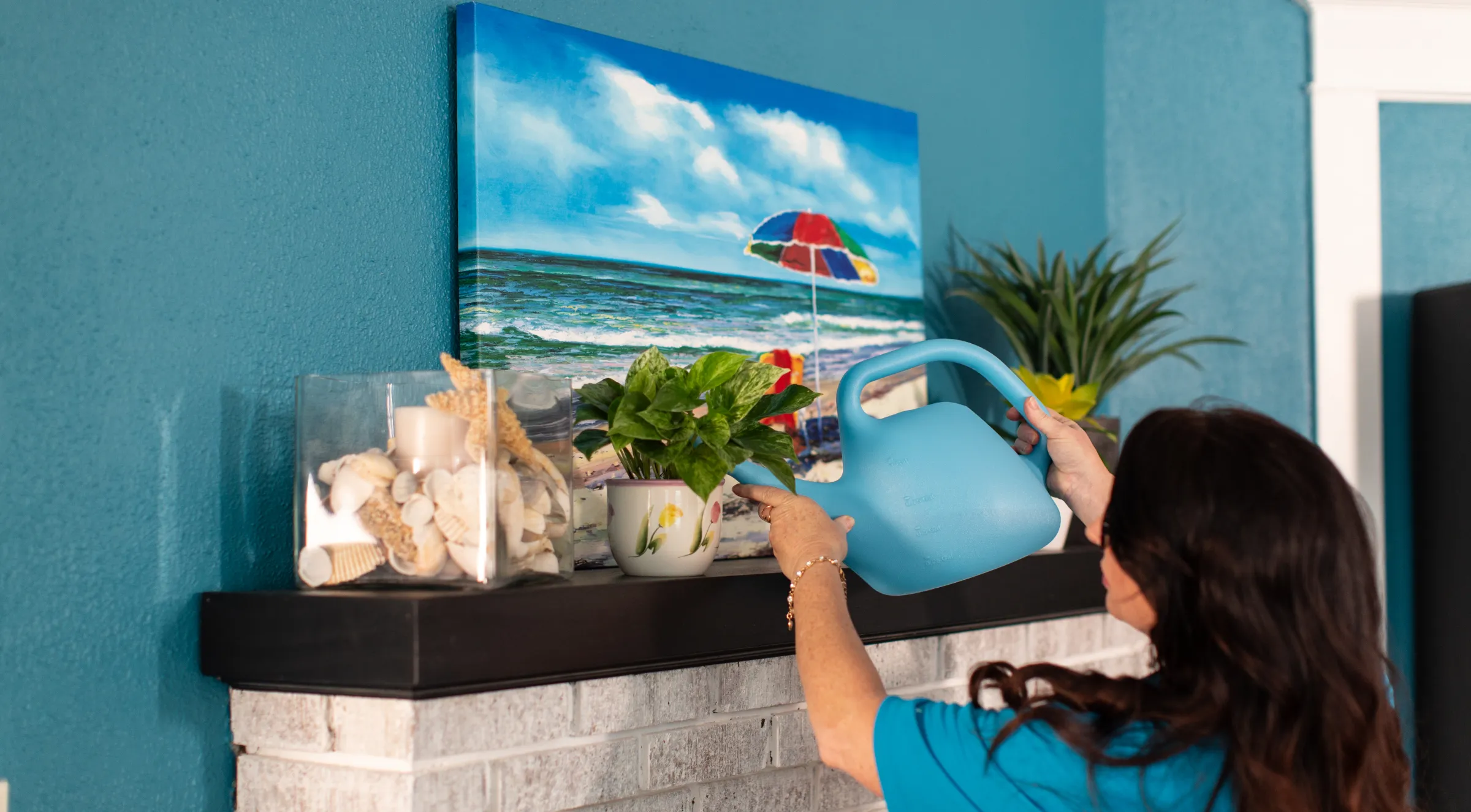A Sandcastle caregiver watering plants in a client's home