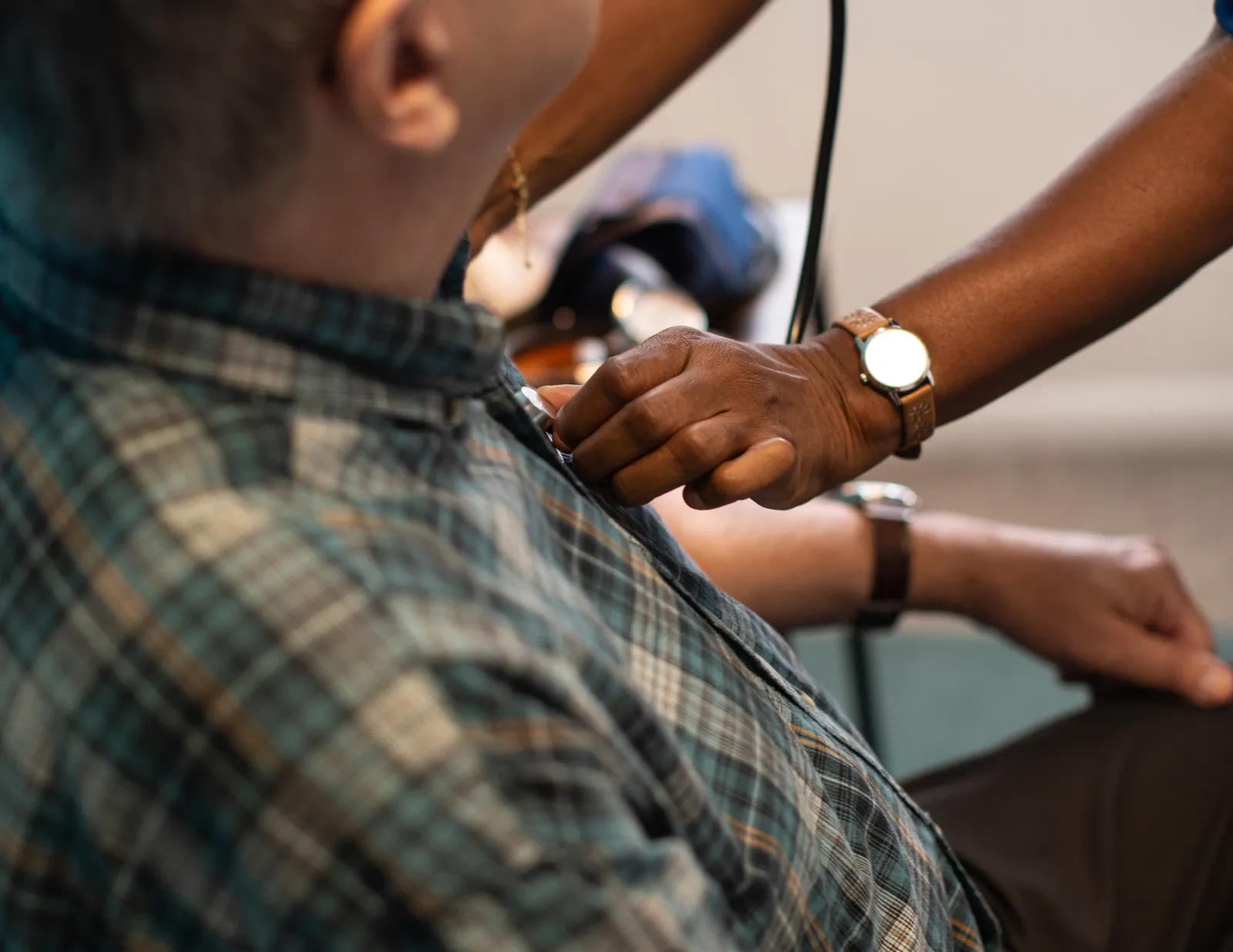 A caregiver checking an older man’s blood pressure