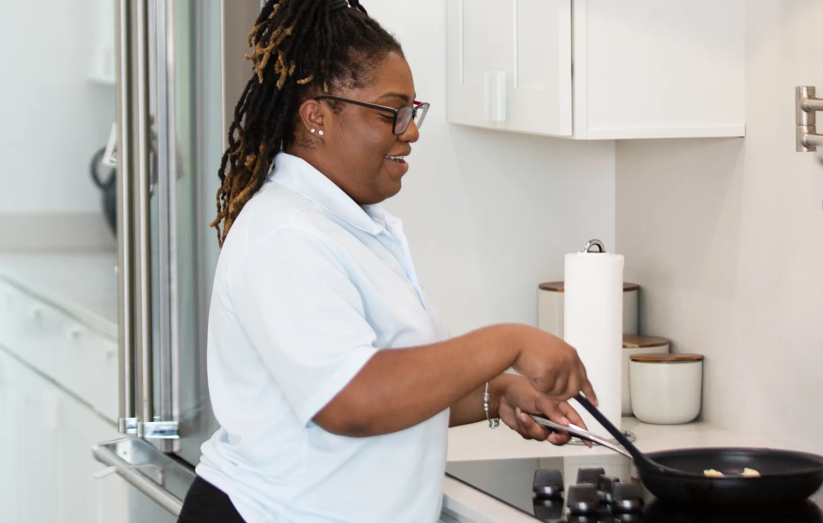 A caregiver cooking at the stove in a home kitchen