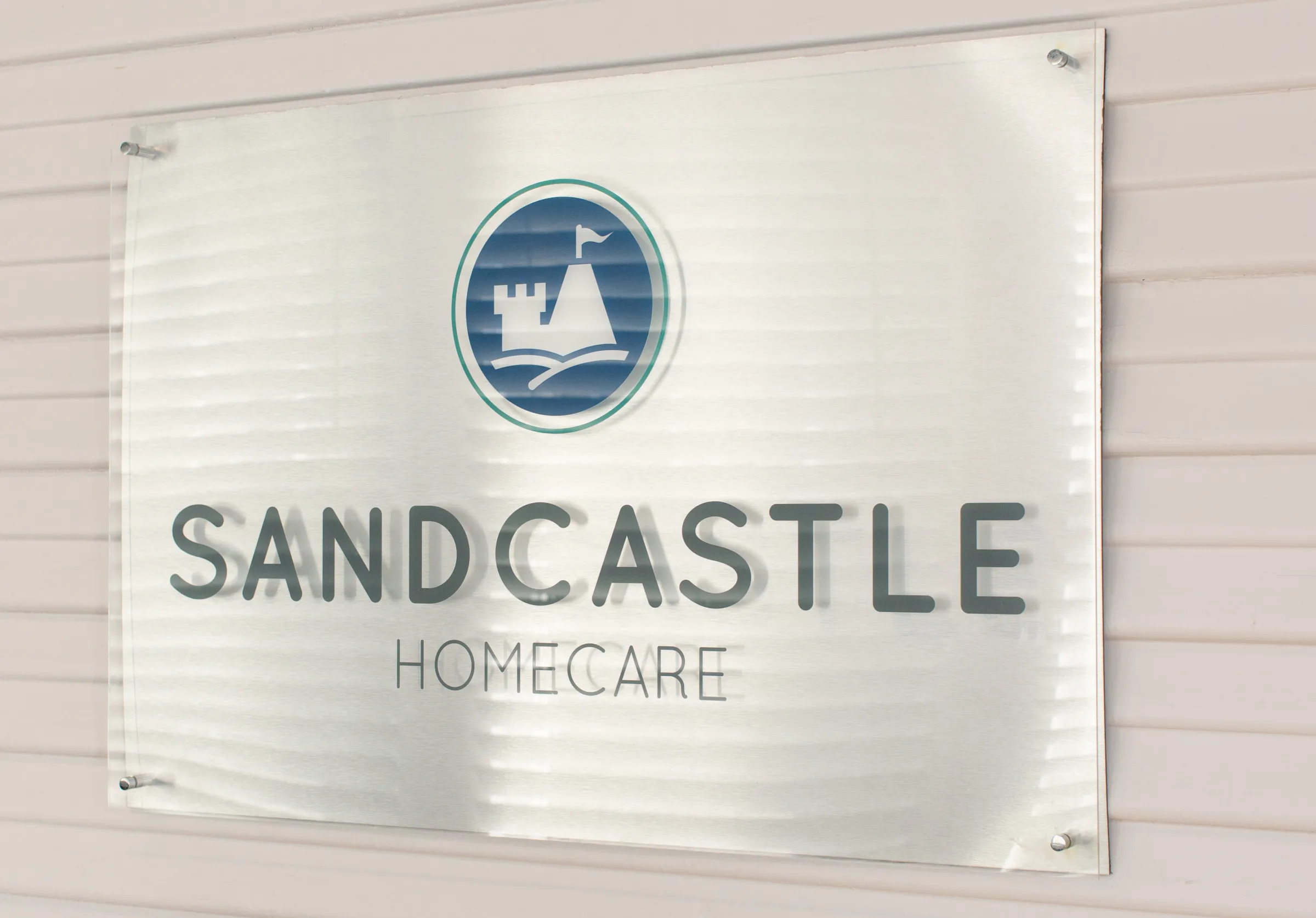 The Sandcastle Homecare sign on an office wall