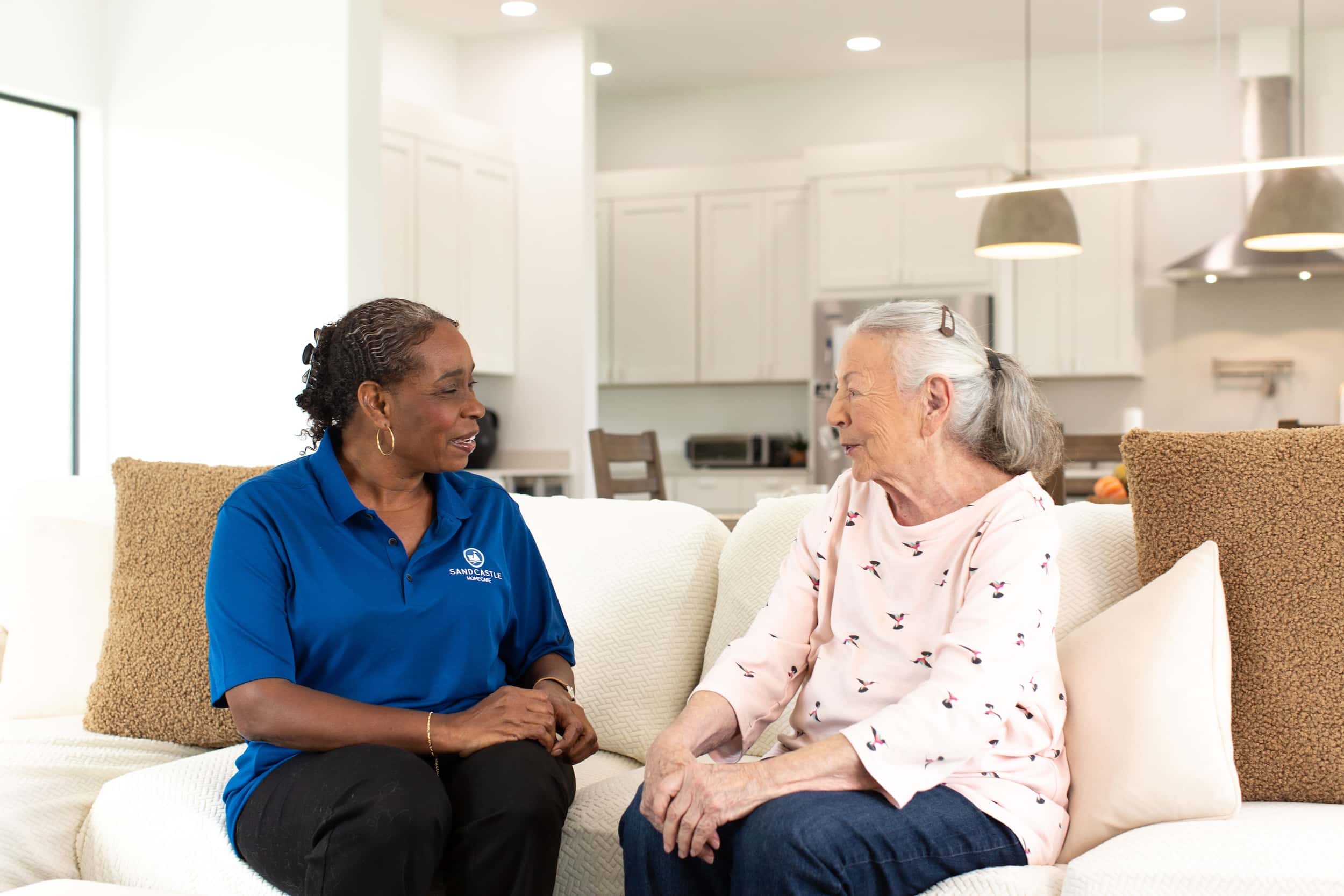caregiver and patient sitting on a couch talking